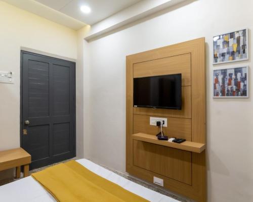 a room with a door and a television on a wall at PRINCE RESIDENCY CLUB HOUSE in Jamnagar