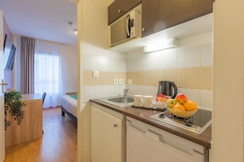 a kitchen with a bowl of fruit on a counter at Appart’City Confort Nantes Centre in Nantes