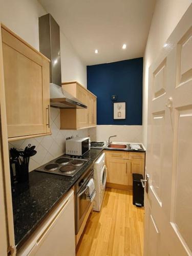 a kitchen with a stove top oven next to a door at Newhall Apartment in Birmingham