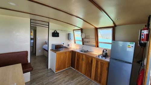 uma cozinha com um frigorífico e um lavatório num reboque em Kraalbaai Lifestyle House Boats em Langebaan