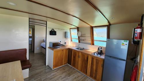 a kitchen with a refrigerator and a sink in a trailer at Kraalbaai Lifestyle House Boats in Langebaan