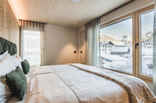 um quarto com uma cama grande e uma janela grande em Amie Chalet em Santa Cristina in Val Gardena