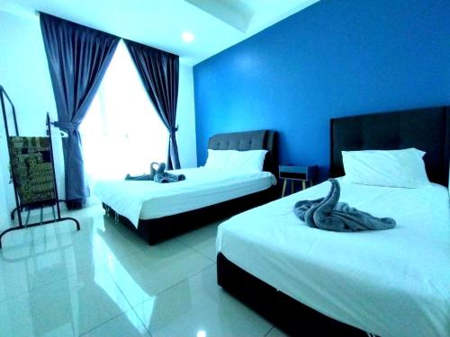 een hotelkamer met 2 bedden en een blauwe muur bij 191 Cozy Casa Kayangan 3BR 6pax by Grab A Stay in Ipoh