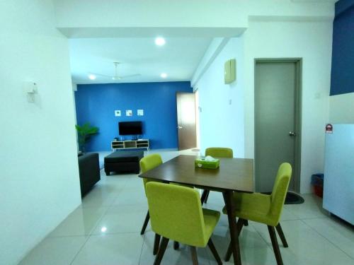 a dining room with a table and yellow chairs at 191 Cozy Casa Kayangan 3BR 6pax by Grab A Stay in Ipoh