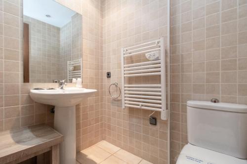a bathroom with a toilet and a sink at Apartamentos Araco 3000 in Pas de la Casa