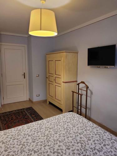 a bedroom with a bed and a flat screen tv at B&B Villa Tavallini in Pollone