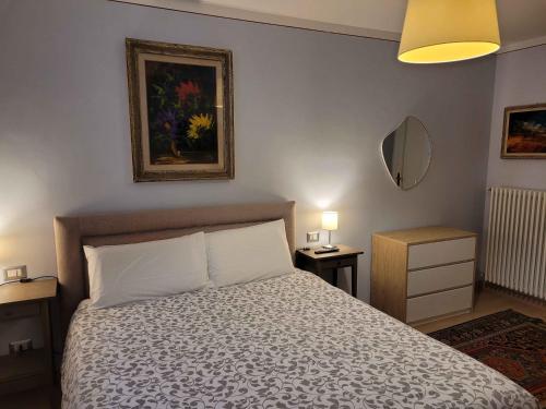 a bedroom with a bed and two tables and a mirror at B&B Villa Tavallini in Pollone