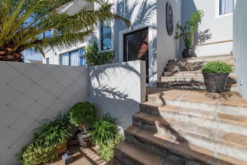 a house with stairs and plants on it at Hout & About Guest House in Hout Bay