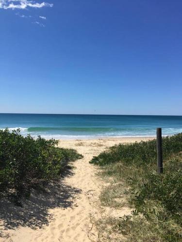 a sandy beach with the ocean in the background at Coastal Hideaway in Windang