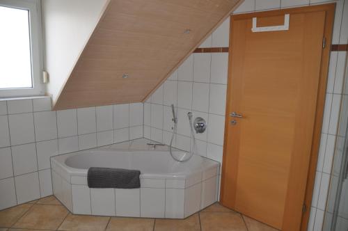 La salle de bains mansardée est pourvue d'une baignoire. dans l'établissement Schnurs Ferienwohnung, à Römerberg