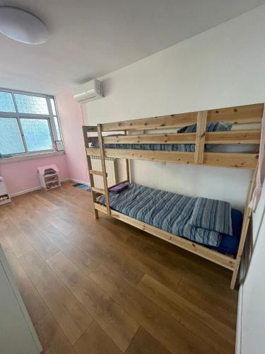 a room with two bunk beds and a wooden floor at The Green House in Bet HaKerem