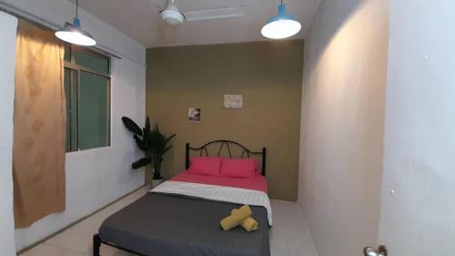 a small bedroom with a bed with pink pillows at 3 rooms PV3 at DANAU KOTA SETAPAK in Kuala Lumpur