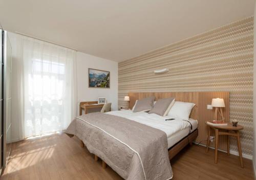 CollombeyにあるAlp Art Hotel Montheyのベッドルーム(大型ベッド1台、窓付)