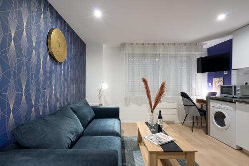 uma sala de estar com um sofá azul e uma cozinha em THEM'APPART CHARTRONS em Bordeaux