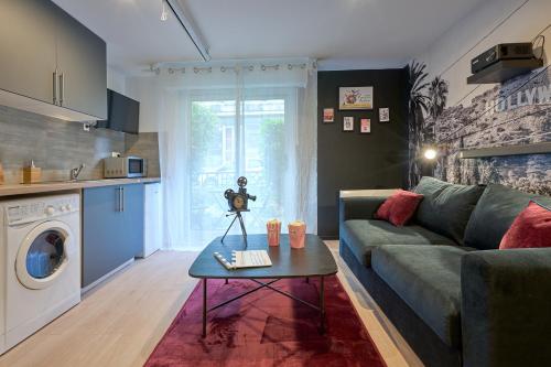 uma sala de estar com um sofá e uma mesa em THEM'APPART CHARTRONS em Bordeaux