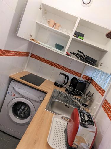 eine Küche mit einer Waschmaschine und einem Waschbecken in der Unterkunft à 30 minutes de tour Eiffel in Montreuil