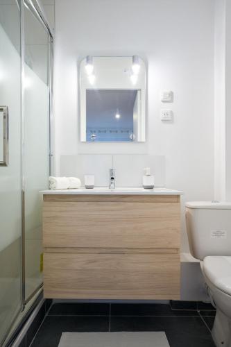une salle de bain avec un lavabo, des toilettes et un miroir dans l'établissement THEM'APPARTS Bordeaux Chartrons, à Bordeaux