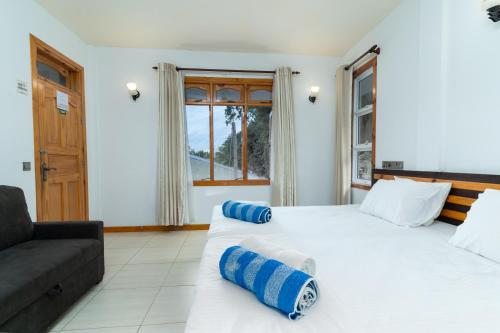 ein Schlafzimmer mit einem großen weißen Bett und einem Sofa in der Unterkunft Ukulhas View in Ukulhas