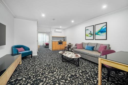 a living room with a couch and a table at Quality Hotel Parklake Shepparton in Shepparton