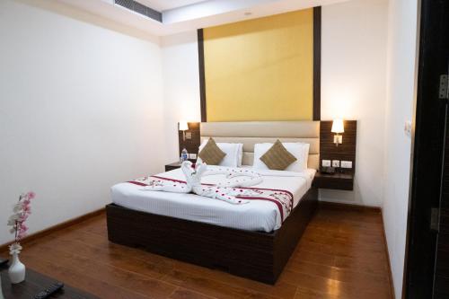 a hotel room with a bed with red and white sheets at Hyphen Premier-Business Hotel in Meerut
