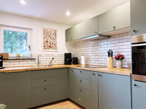 a kitchen with white cabinets and a sink at Design Chalet Vulkaneifel in Kerschenbach