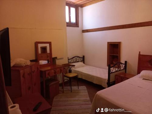 a room with two beds and a desk and a mirror at Tarihi Taşkıran Otel in Beypazarı