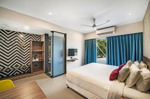 sypialnia z łóżkiem i przesuwnymi szklanymi drzwiami w obiekcie Regency Tuticorin by GRT Hotels w mieście Tuticorin