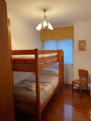 - une chambre avec 2 lits superposés et une chaise dans l'établissement Casa Goros II, à Melide