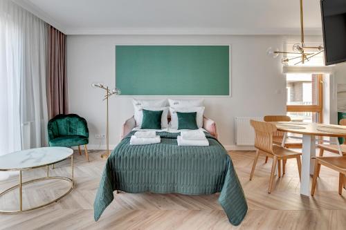 um quarto com uma cama, uma mesa e cadeiras em Downtown Apartments Riverside Nadmotławie - Sauna, Gym & Parking em Gdansk