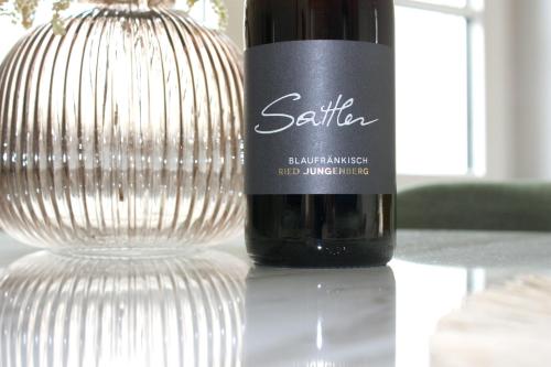 a bottle of wine sitting next to a glass at Villa SEEhnsucht in Jois