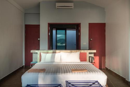 um quarto com uma cama grande e paredes vermelhas em The Sanctuary Nam Ngum Beach Resort em Vang Vieng