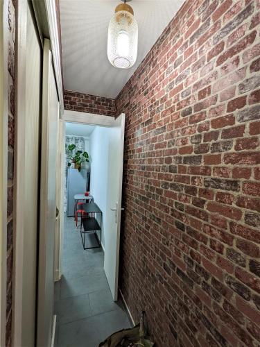 a hallway with a brick wall and a light fixture at à 30 minutes de tour Eiffel in Montreuil