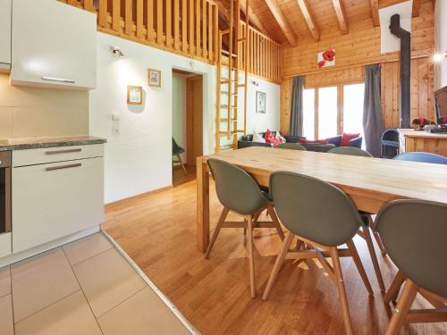cocina y comedor con mesa de madera y sillas en Apartment Grives by Interhome, en Les Collons