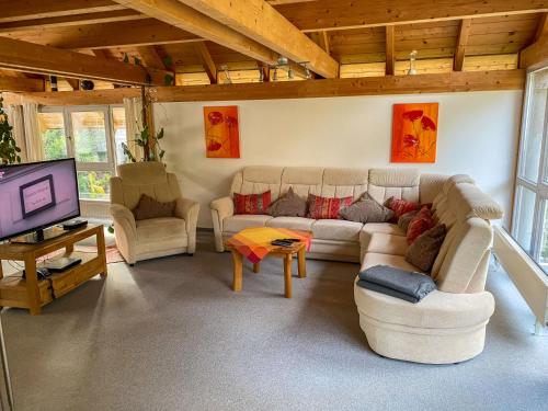 a living room with couches and a flat screen tv at Chalet Christine by Interhome in Molberting