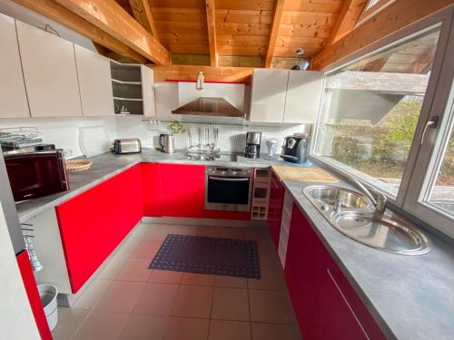 a kitchen with red cabinets and a sink at Chalet Christine by Interhome in Molberting