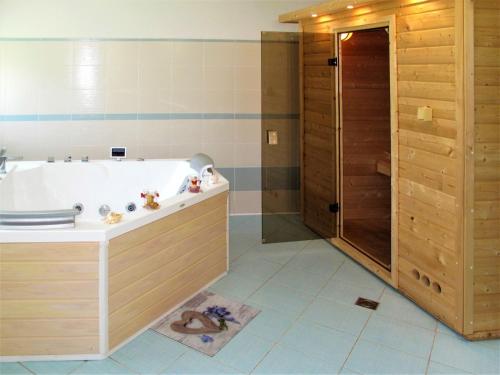 ein großes Bad mit einer Badewanne und einer Dusche in der Unterkunft Holiday Home Jitka - MIR100 by Interhome in Jablonné nad Orlicí