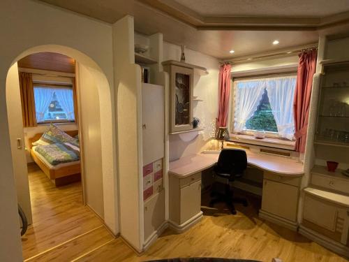 ファルハントにあるApartment Wank by Interhomeのデスクとベッドルームが備わる小さな客室です。