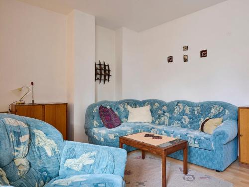 salon z 2 niebieskimi kanapami i stołem w obiekcie Apartment Klondajk by Interhome w mieście Harrachov
