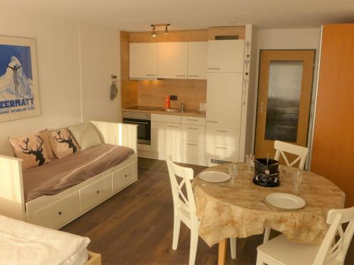 a kitchen and living room with a table and a couch at Apartment Select by Interhome in Zermatt