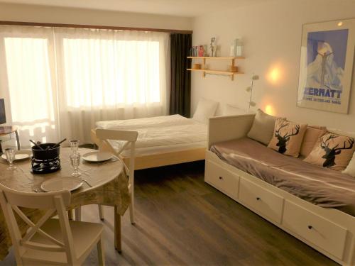 ein kleines Zimmer mit einem Bett, einem Tisch und einem Esszimmer in der Unterkunft Apartment Select by Interhome in Zermatt