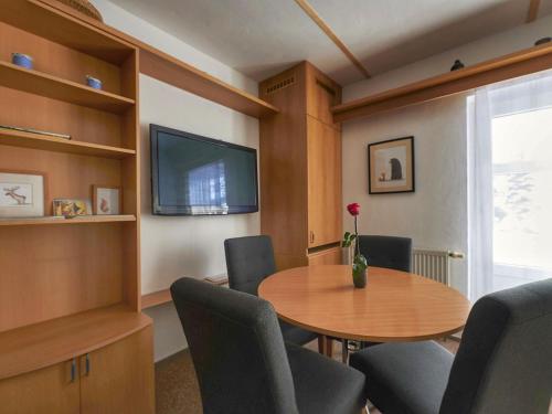 ハルラホフにあるApartment Harrachovka - HRA102 by Interhomeのテーブル、椅子、テレビが備わる客室です。