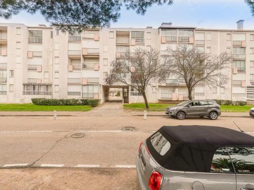 une voiture garée sur un parking devant un immeuble dans l'établissement Apartment Los Amigos-4 by Interhome, au Grau-du-Roi