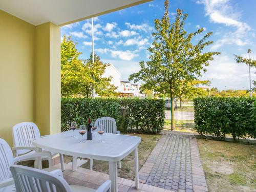 una mesa blanca y sillas en un patio en Apartment Robinia-Pinetine-4 by Interhome, en Duna Verde