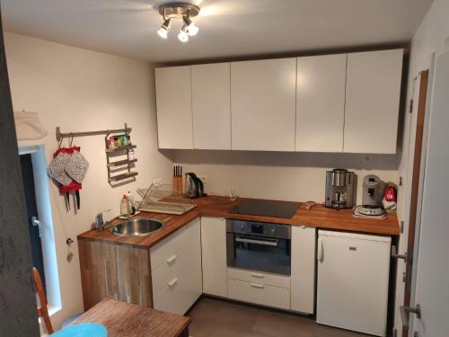 a kitchen with white cabinets and a sink at Villa Le Ti' Bauduin by Interhome in Thy-le-Bauduin