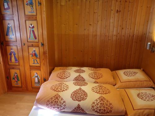 Cama en habitación con pared de madera en Apartment Montana by Interhome, en Langwies