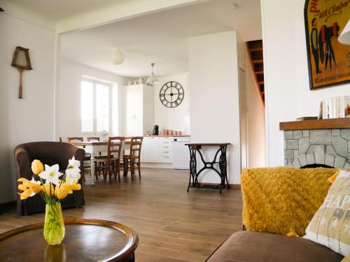 a living room with a vase of flowers on a table at Holiday Home Passerat by Interhome in Maurs