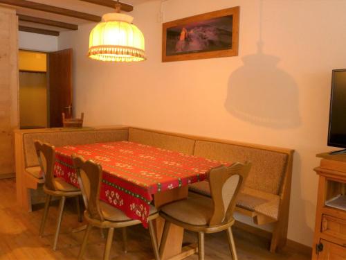 een eetkamer met een tafel en stoelen met een rode tafelkleed bij Apartment Matten - Utoring-18 by Interhome in Zermatt