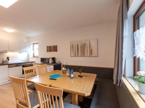 a kitchen and dining room with a wooden table and chairs at Apartment Alpenchalets - ZSE204 by Interhome in Zell am See