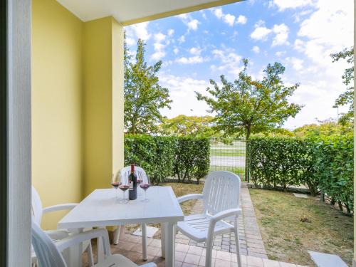una mesa blanca y sillas en un patio en Apartment Robinia-Pinetine-2 by Interhome, en Duna Verde