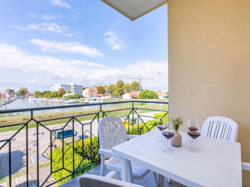 een witte tafel met twee glazen wijn op een balkon bij Apartment Albatros-1 by Interhome in Caorle